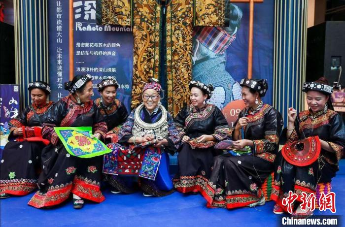 图为潘玉珍老人(中)与其他绣娘一起展示刺绣技艺。 受访者供图